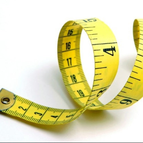 A yellow retractable tape measure with black printed measurement markings and numbers, curled into loops on a plain white background.